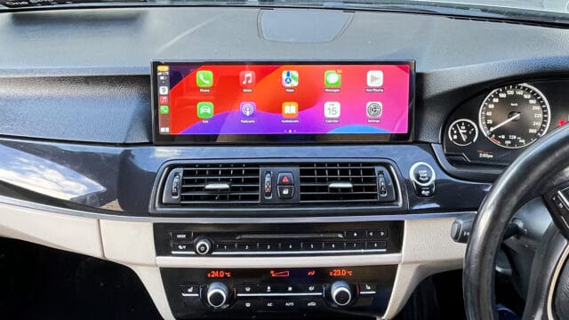 Android car radio display with Apple CarPlay interface in vehicle dashboard.