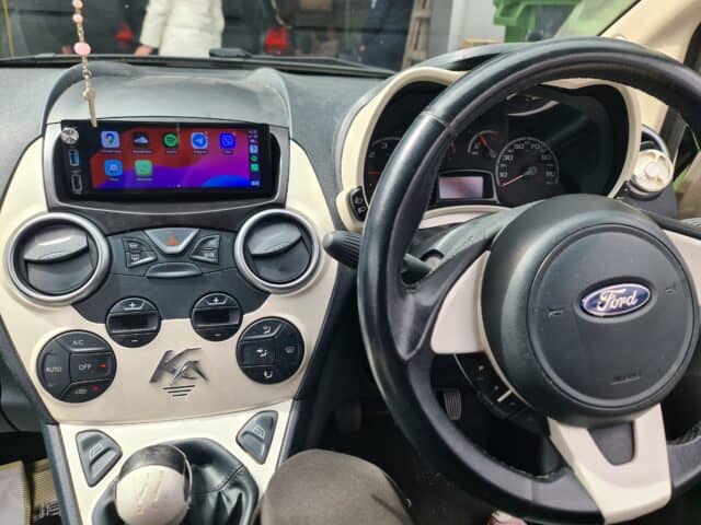 Android car radio system with CarPlay on a Ford vehicle dashboard, featuring touchscreen display and modern controls.