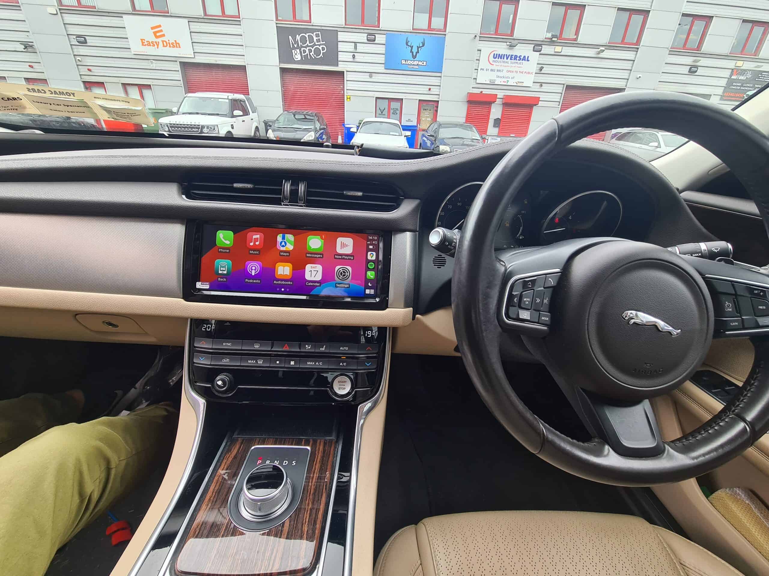 Android car stereo with Apple CarPlay system installed in a Jaguar vehicle interior.