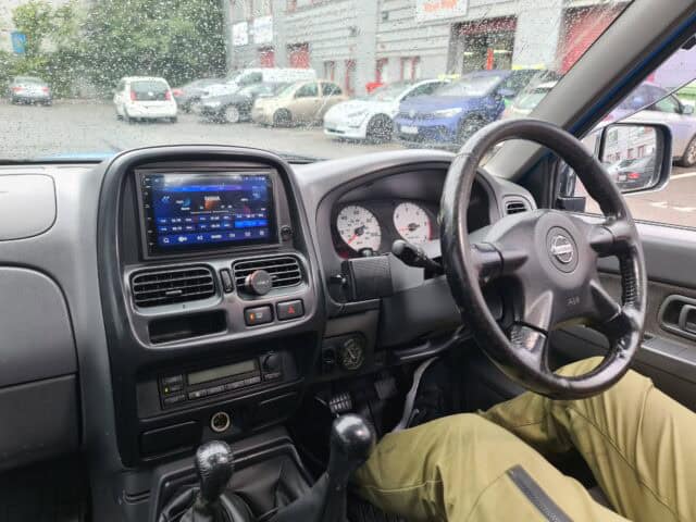 Android car radio with CarPlay system installed in vehicle dashboard, featuring touchscreen display.