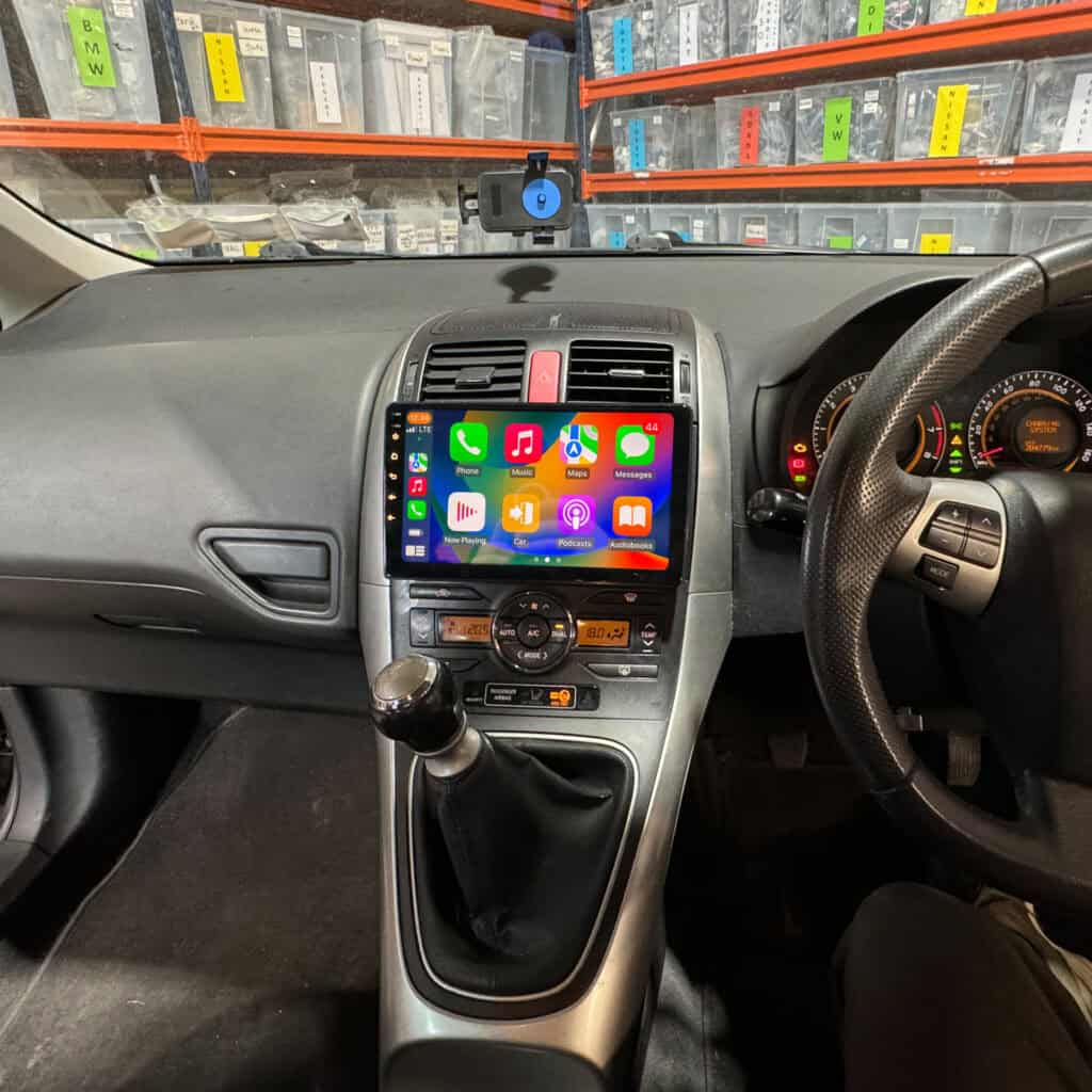 Android car radio with Apple CarPlay system installed in a vehicle dashboard aligned for iPhone connectivity and multimedia control.