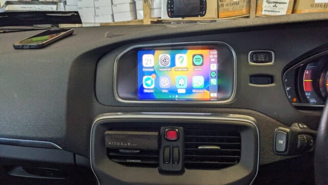 Android car radio with CarPlay system running apps like Spotify and WhatsApp on a vehicle dashboard.
