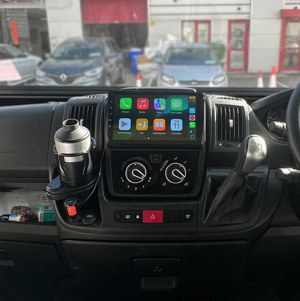Android car stereo system with Apple CarPlay interface in a vehicle dashboard.